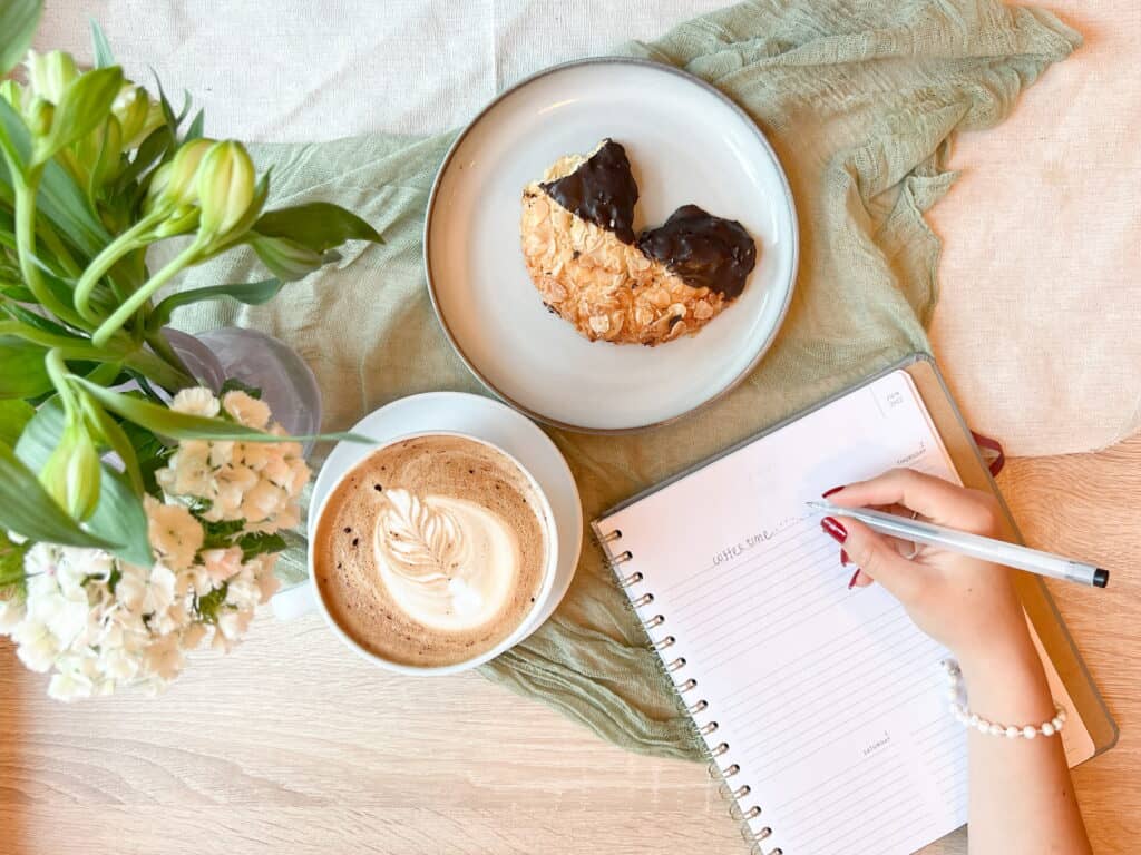 Ein Kaffee Latte mit einem Mandelhörnchen.